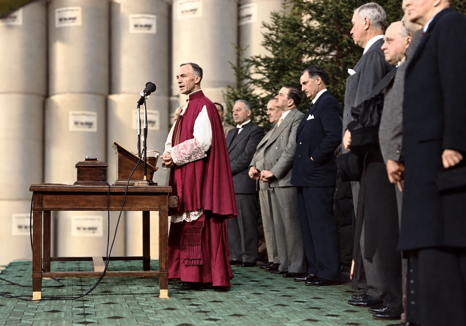 Mons. Napoleón-Alexandre Labrie pronuncia un discurso en una ceremonia, rodeado de dignatarios